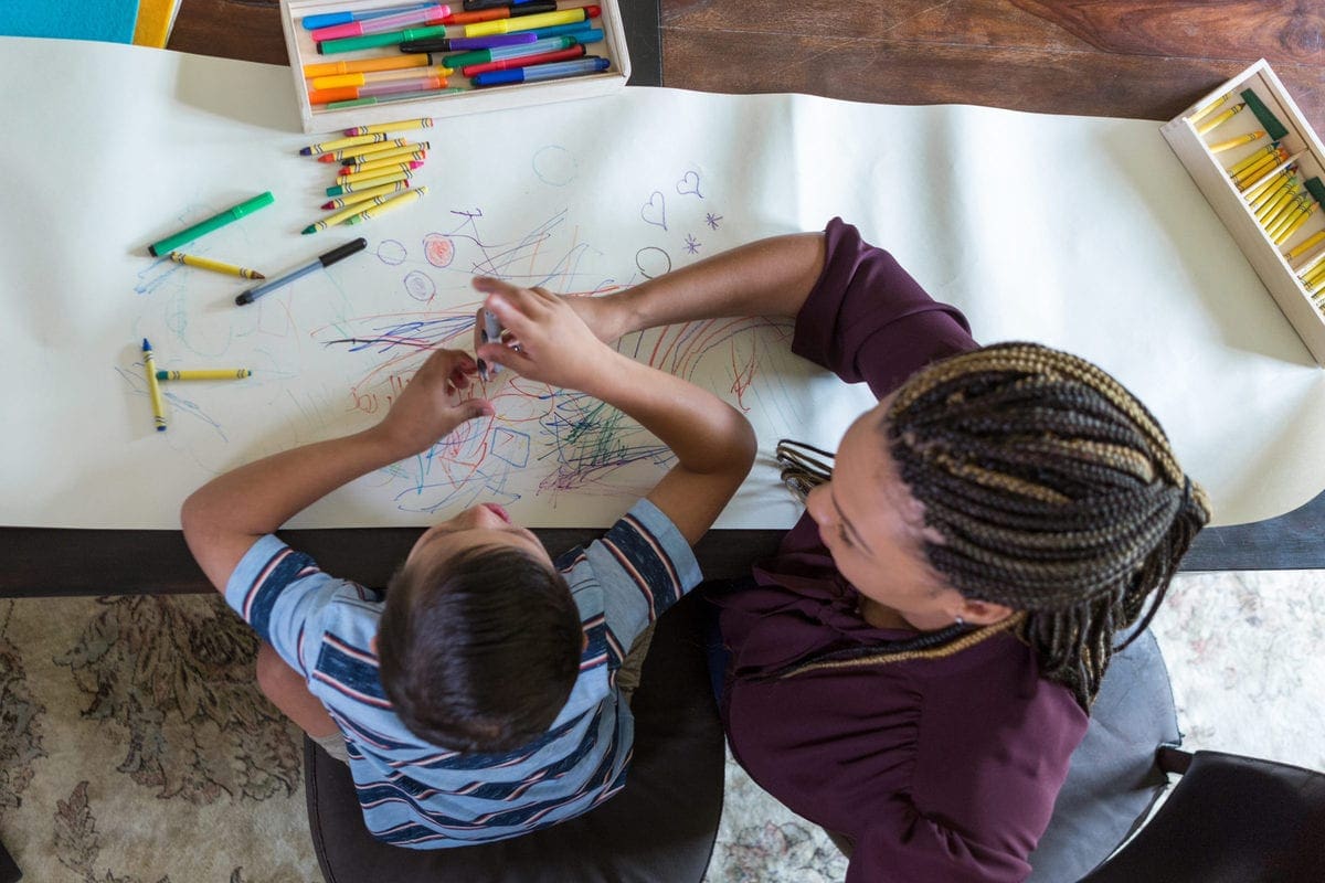 Play therapist colors with boy with Down Syndrome